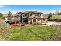 Stunning two-story stucco home with stone accents, mature landscaping, and a well-manicured front lawn at 3891 Windchant Cir, Castle Rock, CO 80104