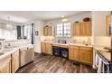 Well-lit kitchen includes wooden cabinets, white countertops, and dual wine coolers at 8976 Fox Dr # 101, Thornton, CO 80260
