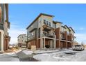 Townhome exteriors showcasing brick and siding, balconies, and snow-covered grounds at 7856 W 43Rd Pl, Wheat Ridge, CO 80033