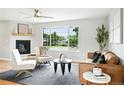 Bright living room featuring a fireplace, hardwood floors, and large picture window at 10320 W 35Th Ave, Wheat Ridge, CO 80033