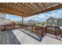 Inviting covered deck featuring wood railings and views of the neighborhood and sky at 6147 N Flanders St, Aurora, CO 80019