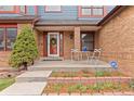 Charming home exterior with brick facade, colorful accents, and inviting front patio with mature landscaping at 16234 E Belleview Dr, Centennial, CO 80015
