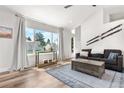Sunlit living room with large windows, vaulted ceiling, and hardwood floors at 6604 S Dahlia Cir, Centennial, CO 80121