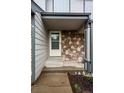 Inviting covered front entry with stone accents and neutral siding at 2002 E 102Nd Cir, Thornton, CO 80229