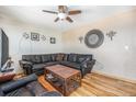 Comfortable living space featuring hardwood floors, a sectional sofa, and a decorative wall clock at 8244 Clemson Ln, Westminster, CO 80031