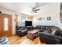 Inviting living room with hardwood floors, comfortable leather seating, and a bright window creating a cozy atmosphere at 8244 Clemson Ln, Westminster, CO 80031