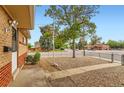 Street view of a charming home with low-maintenance gravel landscaping and a chain-link fence at 6930 Warren Dr, Denver, CO 80221