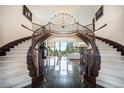 Grand foyer features a double staircase, marble floors, and a chandelier, showcasing the home's luxurious design at 8337 Greenwood Dr, Niwot, CO 80503