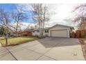 Front view of a house with a large yard and driveway at 3460 W 131St Ave, Broomfield, CO 80020