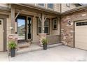 Inviting front entrance with stone pillars, glass door and welcome mat at 8107 Arapahoe Peak St, Littleton, CO 80125