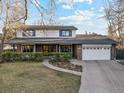 Beautiful two-story home featuring a well-maintained lawn, brick details, and a two-car garage at 1998 S Harlan Ct, Lakewood, CO 80227