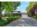 Charming two-story home features a manicured lawn, brick accents, and an attached two-car garage at 1998 S Harlan Ct, Lakewood, CO 80227