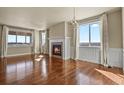 Bright living room featuring a cozy fireplace and large windows with scenic views at 20132 Spruce Point Pl, Parker, CO 80134