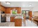 Traditional kitchen with wooden cabinets, granite countertops, and an island with bar seating at 5987 W Ken Caryl Pl, Littleton, CO 80128