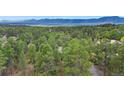 Expansive aerial view of a lush forest and mountains in the distance at 1185 Fawnwood Rd, Monument, CO 80132