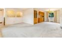 Bright living room features neutral walls and carpets, and a partial view of the kitchen at 2180 S Flower Way, Lakewood, CO 80227