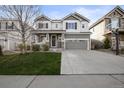 Charming two-story home with a well-manicured lawn, covered porch, and a two-car garage offers classic curb appeal at 2198 Broadleaf Loop, Castle Rock, CO 80109