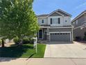Charming two-story home with gray exterior, well-manicured lawn, and a 'Welcome' sign on the porch at 2198 Broadleaf Loop, Castle Rock, CO 80109