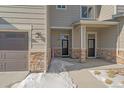 Townhome's front entry with stone accents and covered porch at 12255 Hazel Spruce Ct, Parker, CO 80134