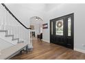 Inviting entryway with hardwood floors, staircase, bench, and a decorative wreath on the front door at 2370 W 152Nd Ave, Broomfield, CO 80023