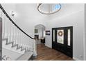 Bright foyer featuring hardwood floors, a staircase, and a view into the living room with a fireplace at 2370 W 152Nd Ave, Broomfield, CO 80023