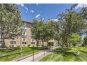 Exterior view of the building featuring mature trees, well-kept lawns, and a welcoming entrance at 3124 S Wheeling Way # 102, Aurora, CO 80014