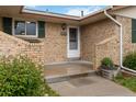 Close-up of the front door, showcasing brick accents, planter, and the house number 6288 at 6288 S Harlan Way, Littleton, CO 80123