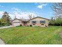 Charming brick home with a lush green lawn, attached garage, and inviting curb appeal at 6288 S Harlan Way, Littleton, CO 80123
