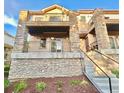 Detailed exterior showcases stone accents, private balconies, and inviting entrance stairs at 3155 E 104Th Ave # 4E, Thornton, CO 80233