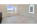 Spacious and bright living room with large windows offering plenty of natural light, and light wood floors at 641 Skyhook St, Erie, CO 80516