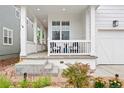 Inviting covered front porch with white railing, chairs, and steps leading to a meticulously landscaped garden at 2027 Vallejo Loop, Broomfield, CO 80023