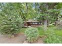 Lovely home exterior surrounded by mature trees and lush greenery at 32 Skyline Dr, Wheat Ridge, CO 80215