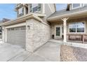 Close-up of the home's exterior showcasing the front entrance, brick accents, and attached two car garage at 5625 S Buchanan St, Aurora, CO 80016