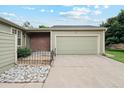 Charming exterior featuring a 2-car garage, lovely green paint, and a rock feature in the front yard at 14333 E Warren Pl, Aurora, CO 80014