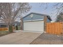 Attached two-car garage featuring new paint, a concrete driveway, and simple landscaping at 4234 S Bahama St, Aurora, CO 80013