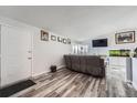 Comfortable living room with wood floors, a large gray sofa, and a flat-screen TV at 4234 S Bahama St, Aurora, CO 80013