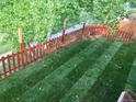 New sod backyard with a red wooden fence at 15972 W 70Th Dr, Arvada, CO 80007