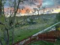 Sunset view over houses and grassy backyard with fence at 15972 W 70Th Dr, Arvada, CO 80007