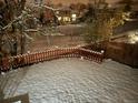 Snow covered backyard with a wooden fence and houses in background at 15972 W 70Th Dr, Arvada, CO 80007