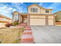 Lovely two-story home with a three-car garage and brick accents, offering curb appeal at 15972 W 70Th Dr, Arvada, CO 80007