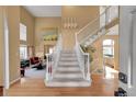 Grand foyer featuring a staircase, hardwood floors, and views of the living and dining areas at 15972 W 70Th Dr, Arvada, CO 80007