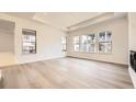 Bright and airy living room showcasing large windows, tray ceiling, and sleek hardwood floors at 15586 W Beloit Ave, Morrison, CO 80465