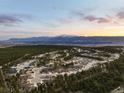 Breathtaking aerial view of a residential area nestled among trees with a mountain view in the background at 1775 Catnap Ln, Monument, CO 80132