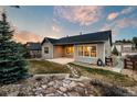 A serene backyard featuring a patio, lush lawn, stone accents, and a charming walking path at 1775 Catnap Ln, Monument, CO 80132