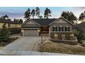 Charming exterior view of home with a two-car garage, stone accents, and attractive landscaping features at 1775 Catnap Ln, Monument, CO 80132