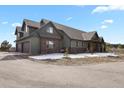 Stunning home exterior showcasing a spacious three-car garage and pristine landscaping at 5800 Elk View Ct, Larkspur, CO 80118