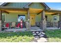 Inviting front porch featuring stone columns, a wooden porch swing and rocking chairs at 5800 Elk View Ct, Larkspur, CO 80118