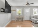 Bright living room with hardwood floors, a ceiling fan and a wall-mounted television with natural light at 4933 Grove St, Denver, CO 80221