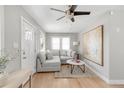 Bright living room with a gray sectional couch, modern art, and light hardwood floors at 4933 Grove St, Denver, CO 80221