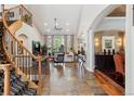 Open-concept living space with high ceilings, stone floors, and a grand staircase at 35 Brookhaven Pl, Littleton, CO 80123